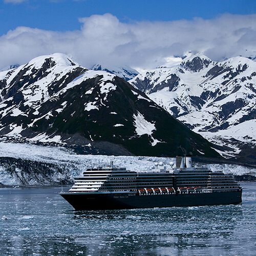 Cruise ship beneath snowy mountains